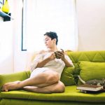 sanya malhotra  in white dress on a green couch with her cat, coffee and books(16)