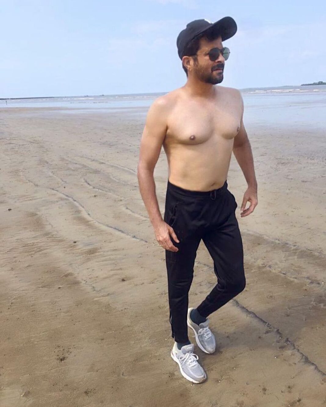 Anil Kapoor Instagram - This papa doesn't preach, just removes his top and walks to the beach 🏖 Everyone has a weak point. Mine is food . The Punjabi boy in me needs the taste buds ignited, my eyes always bigger than my belly 🙈 During lockdown, I have set myself the task of achieving a new sharper look. This new look needs a new approach to eating . Both Harsh and my trainer Marc have taken it upon themselves to remind me constantly and lay down eating plans . I try and I battle . Some times I even fall. And what I've learnt through it all is that a chain is only as strong as it’s weakest link . So everyone in the house had to get involved . From those who kindly cook my food to the support of my family gathered round me at meal time . Fitness is never a one man/ women crusade , it’s about support and encouragement when we need it the most . (Always get family involved and on board to help you in any diet if you wish to make it truely a success ) Is it easy ? Not always, if I am honest. Some days the Punjabi boy sulks a little, but then some days, like this day with this picture... it makes it all worth it...