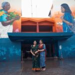Anu Sithara Instagram - “When passing by this striking mural at the KSRTC bus station in Ernakulam, you can’t help but stop for a moment to really appreciate the thought behind this beautiful artwork. The juxtaposition of an old lady carrying local fruits, vegetables and flowers while the young girl is carrying a school bag is so thought provoking. It immediately reminded me of my own grandmother, the bond we share and all the valuable lessons she has taught me about our land and traditions, while I teach her about modern trends and technologies. It’s a wonderful way to celebrate our traditions while embracing the future. The mural is part of @asianpaints Donate A Wall initiative in association with @startindia. It is made by graffiti artist ZERO and assistant OneStroke and is featured prominently on the façade of the busy bus station. The picture was clicked keeping in mind all the safety precautions for both me and my grandmother.