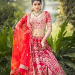 Sai Dhanshika Instagram - This the most classic red Lehenga & green emerald jewelry combo that you can never go wrong with it! 💃@mokshaa_chennai 💎@challani_jewellery 📸 @chethanroyie 🎥 @call_me_taro_ @teamcreators @bharath_d_o_p 💇🏻‍♀️ @mani_hairstylist @varaabysangeethakailash #sabyasachiinspired #sabyasachibride #red #classic #nevergooutofstyle #lehenga #love #poser #naturebackdrop #redlover❤️