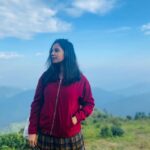 Angana Roy Instagram – Dear mountains, I think about you every now and then.

📸@shieladitya_official 

#throwback #mountains #mountainview #majormissing #hills #creativelifehappylife #mountainstories #hillshaveeyes #red #jacket #skirtandtop #blueskies #picturesque #naturephotography #naturelover #sittong #kurseong #travelphotography Sittong-Shelpu-Latpanchor