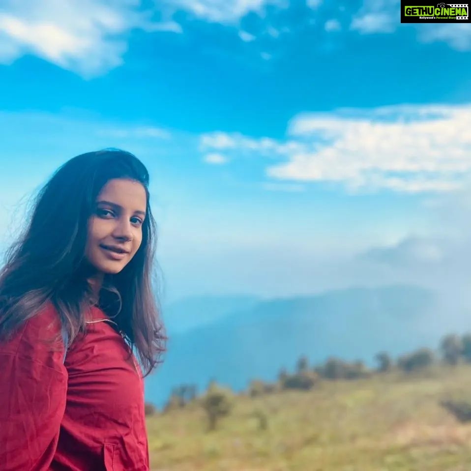 Angana Roy Instagram - Dear mountains, I think about you every now and then. 📸@shieladitya_official #throwback #mountains #mountainview #majormissing #hills #creativelifehappylife #mountainstories #hillshaveeyes #red #jacket #skirtandtop #blueskies #picturesque #naturephotography #naturelover #sittong #kurseong #travelphotography Sittong-Shelpu-Latpanchor