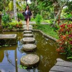 Aparnaa Bajpai Instagram - Tippy toes👣 Walking through life be like. Head to @roamingaffair to read more about my travels! See! We weren't wrong when we said that Bali in itself is an embodiment of Beauty.. This is just a basic entrance to a small little cozy hotel we stayed in, in ubud. After a great stay in a resort, we just randomly stumbled upon this place online and made a spontaneous plan to spend two days here as well and we are more than glad that we did that. It's not very far from Ubud center but man,.. It's hell of a ride to get here. We had three suitcases and a couple of bags plus a guitar all piled up on scooter. Not only the luggage but both of us were also piled on the scooty one by one, to be taken through a narrow street in the middle of enormously beautiful rice pads. Up and down we went through the kind of hilly and narrow patch and landed in front of a beautiful retreat/villa/hotel. We spent our most amazing 2 days here, eating healthy food, going for sauna and watching people do yoga 🙈 We were too lazy to participate in it and made our peace with just being spectators😁 All in all, we are trying to say that we love bali❤️ . . . #welovebali #bali #travel #traveller #blogger #glocalchild #sonyalpha #knowbali #travelbucketlist #travelholic #travelgram #travelshot #goglocal Dragonfly Village