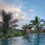 Aparnaa Bajpai Instagram - Honestly, it has always been my dream to get a picture perfect moment at an infinity pool with a larger than life view. When you look at dozens of pics floating online with such exotic and mermaid like pictures all around, you can't help but get lured to experience something this divine. Now.. This is what you expect and aim for but what you get is, believe me; even more spectacular. This pool was heated to the goldy locks temperature and once we got inside we never wanted to come out. Clicking pictures was something we eventually pushed ourselves to do but what we really enjoyed was to just stay in and stare away at the infinite view which stood before us. Watching the sun go down and the sky turning complete dark with little glimpse of lights flickering at some extreme end, actually gave a feeling as we are all alone in this nothingness and yet so close to nature and in touch with something so blissful. The warm mist rising up from the water, the sound of the water falling and splashing down from the parapet and the gush of wind adjusting speed from time to time and the occasional croaking of toads, is all those things which you will experience here. And also remember! Or you actually might remember the moment you captured too. That's what pictures are for. Right? #bali #ubud #travel #glocalchild #blogger #traveller #mytravelstories Padma Resort Ubud