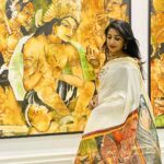 Navya Nair Instagram – Thank u so much @sreerani_online  fr this beautiful@painting and hand painted mural saree .. 

Accessories @chinkaari_collections 

*The Saree* 
The painiting is of Padmapani Bodhisattwa from the paintings of Ajanta caves. A good amount of exploration was done to get the authentic paintings. The human components and most of the other components in the painting except for the ornaments were painted using faded out approach. This was to bring out the grandeur of the ornaments and still give the painting an antique look. Painted using fabric acrylic paints. The size is 26″X40″. The painting is done on Special handwoven Balaramapuram Sreerani saree series. The yarn used is 100% best quality Unakku Pavu cotton yarn. This is further enriched with 3 inches bold Golden colour Kasavu on the Mundani/Pallu. Priced at Rs. 20,400.

*The Wall Painting* 
The painting is from the Ajantha caves and is of Prince Siddharth having a worldly life with lot of people posted to attend to him and serve him so that he doesn’t come across the realities of life like hunger, old age etc. The Artist has endeavoured and has accomplished to the bring the antique and worn out look in the painting by employing the Wash & sponging techniques using the water colour method. Professional quality Winsor & Newton’s Acrylic medium to ensure long lasting colour quality. The painting is done in 3 pieces of canvas 2 measuring 25″ X 50″ each which goes on both the sides of a 50″X50″ middle piece. Priced at Rs. 1,44,000.