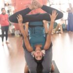 Sanjjanaa Instagram - Releasing a set of wonderful yoga pics … reliving previous yoga days of my life … #gocoronago … Because of the COVID having a digital celebration of international yoga day today .. sharing pics on my Instagram .. Email us if you need wonderful new videos or extract my New yoga videos posted on my Igtv 5 days ago . Feel free to spread the msg of Yoga & good health through these lovely of me performing yoga with my Yoga Guru ji Amar shri Vidya ji … Happy digital international yoga day . I would like to share my knowledge about Acro Yoga , Let’s start with explaining the Roles in Acro Yoga , Roles There are 2 important roles in an Acroyoga practice: The base & the Flyer . Base - this is the individual who has the most points of contact with the ground. Often this person is lying on the ground with the entire back torso in full contact. This enables both the arms and legs to be "bone-stacked" for maximum stability and support of the Flyer. Main points of contact with the flyer are the feet (generally placed on the Flyer's hips, groin or Abs ) and the hands (which either form handholds or grasp the shoulders). Flyer {referring to my self in the pic } - this is the individual who is elevated off the ground by the Base {base partner is Referer to my Guru ji in the pic } . The Flyer can move into a series of dynamic positions, A Flyer needs balance, confidence, and core strength developed over years of practice through Yoga / Acro yoga . (Continued… ) Bangalore, India