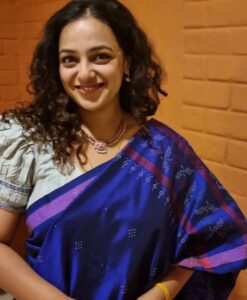 Nithya Menen Instagram - Tangaliya or Daana weaving 🧵  from Gujarat is mainly practiced by the Dangasia community. It's history spans back over 700 years ! :) 🕰 

 The legend goes, that a young man from the shepherding community of Bhadwad , fell in love with a young lady from a neighbouring weaving community🧶 and married her .  His family disapproved of the match, and the young couple were made unwelcome. So they settled with her family of weavers and he continued to herd sheep. As he learnt the craft of weaving, he started to use the wool from his sheep 🐑  and thus the art of Tangaliya weaving came into being !  Within the Dangasias and Bhadwads communities, no special occasion was complete without draping or gifting tangaliya weave 

This craft was unknown to the world until 2007-2008, when it received the GI (Geographical Indication) certification, during the design intervention project by NIFT. The Dangasia community became well known for their tangaliya weaving. However, when the project ended the system started to lose its dynamics.

Today, with the introduction of less expensive, printed textiles in the market, many traditional weavers and their descendants are sustaining themselves by working as labourers in factories and farms or migrating to the cities in search of working opportunities.
@isha.savetheweave 
Thank you @lakkarajusailaja for letting me wear your mothers necklace🤎🤎 😊