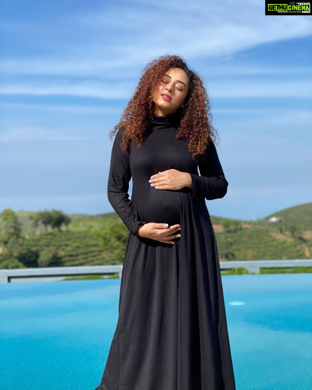 Pearle Maaney Instagram - The blue sky... Green meadowlands and... the lady in Black 😋🧿 . Babymooning in Vagamon🥰 📸 @srinish_aravind . Wearing @momzjoy Palette Hill View Resort