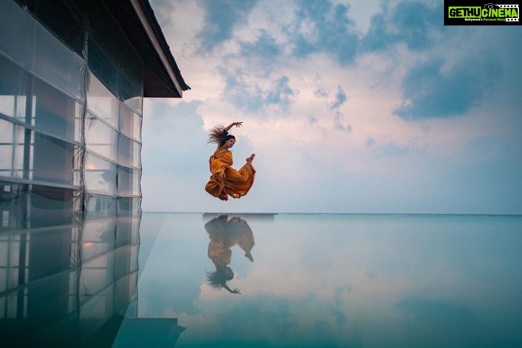 Rukmini Vijayakumar Instagram - Floating in air between the sky and water ….. I wish I led life like this photo…. Flying through everything with ease… :-) Photo @vivianambrose #jump #ocean #sky #bluesky #dancer #dancerlife #suspend #levitate #indiandance #indiandancer
