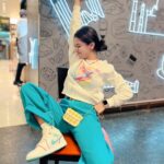 Avneet Kaur Instagram - Who set my mood on shuffle?😅 🌸OUTFIT DEETS 🌸 Sweatshirt- @hm Pants- @urbanic_in Shoes- @nike Bag- @accessorizeindiaofficial Jewellery- @y2_kii @apple Kempegowda International Airport Waiting Area