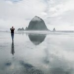 Richa Gangopadhyay Instagram - Here's another reason to add Oregon to your #bucketlist: The Oregon coast! Of the many gorgeous coastal beaches and towns in this state, one of our most frequented ones (especially when anyone comes to visit us!) is Cannon Beach 🌊. The iconic Haystack Rock 🪨 is accessible right from the beach and is an easy, 1.5 hour scenic drive from Portland metro. Cannon Beach has a quaint beach town bustling with saltwater taffy shops (with the wildest flavors!), people window shopping in charming little souvenir shops, loads of breweries, bars and restaurants surrounding a serene coastal residential area nestled in evergreens, mountains and a misty fog all year round (thanks to its own microclimate). You might get lucky on a rare sunny day, but it wouldn't be a Pacific Northwest experience without a little nip in the air! 🏔 We last brought Luca here when he was 8 months old, in a baby carrier, and now at 16 months all he wanted to do was chase his reflection in the glassy sand and fearlessly run into the ocean! Pictured: tiny human alone, dangerously close to the ocean; Not pictured: outgoing tide and 3 adults close by, constantly chasing him! 🌊 Cannon Beach never disappoints- make sure to save it for your visit out to Oregon! 💚 • • • • • #cannonbeach #oregoncoast #pacificnorthwest #pnwbeach #haystackrock #portland #oregon #oregonexplored Cannon Beach, Oregon