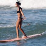 Lisa Haydon Instagram - Have always been scared to surf in Bali.. the waves seem huge and verryyyyy professional. The other day I was surfing a big foam board, so scared after not being in open ocean surfing like this in three years, and sooo rusty. Basically spent the morning in “the laundry” as our teacher Nyoman puts it. Haha, if you know you know 🫣. But as my husband quite rightly says “don’t waste a day in Bali” … in other words, if you don’t get out there, you didn’t live it to the fullest. Second slide has a wee little friend 🐢 that popped his head up a few times this morning 🫶🏽🫶🏽🫶🏽 If you’re ever in Bali head to Batu Balong for some sweet baby waves and ask for Nyoman who will push you onto the wave🙃enjoyyyyy #BaliHai #BaliHigh @lareveche