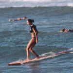 Lisa Haydon Instagram – Have always been scared to surf in Bali.. the waves seem huge and verryyyyy professional. The other day I was surfing a big foam board, so scared after not being in open ocean surfing like this in three years, and sooo rusty. Basically spent the morning in “the laundry” as our teacher Nyoman puts it. Haha, if you know you know 🫣. But as my husband quite rightly says “don’t waste a day in Bali” … in other words, if you don’t get out there, you didn’t live it to the fullest. Second slide has a wee little friend 🐢 that popped his head up a few times this morning 🫶🏽🫶🏽🫶🏽 If you’re ever in Bali head to Batu Balong for some sweet baby waves and ask for Nyoman who will push you onto the wave🙃enjoyyyyy 
#BaliHai #BaliHigh 
@lareveche