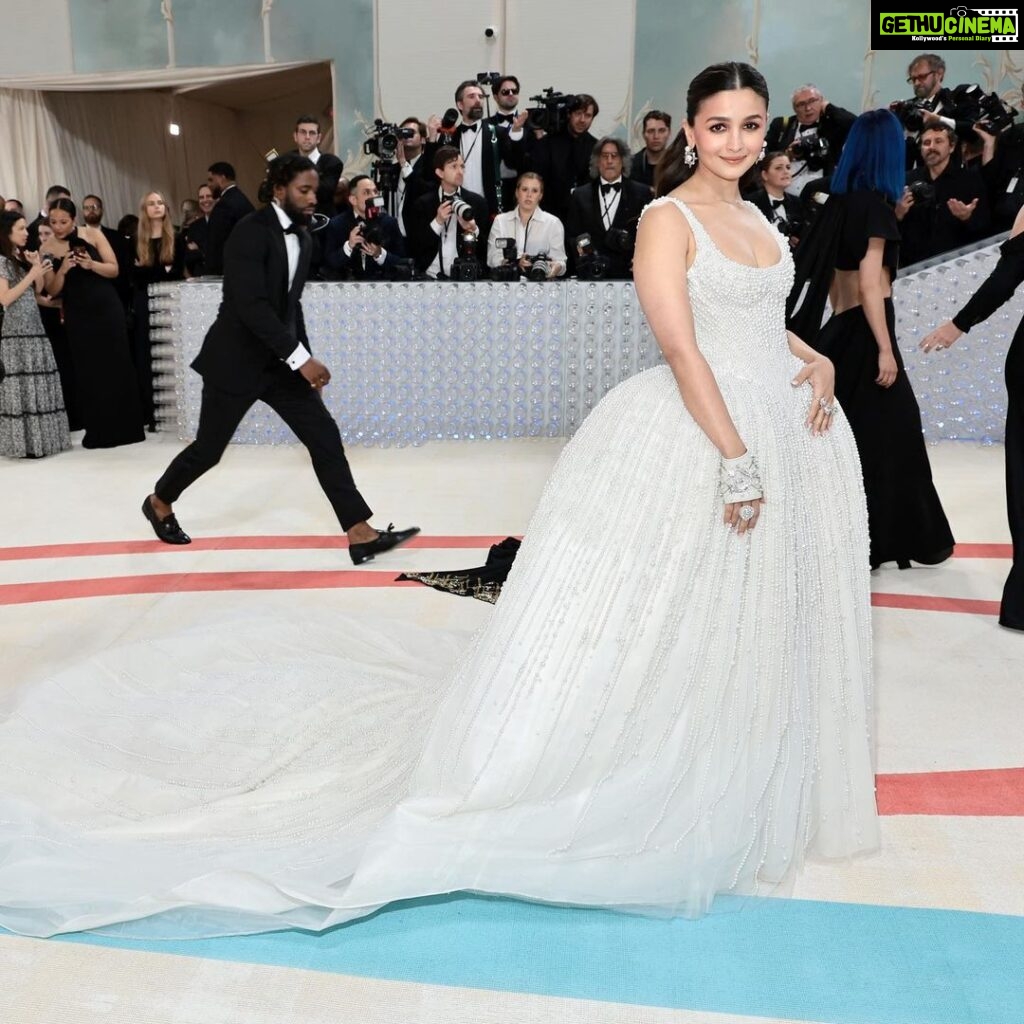 Alia Bhatt Instagram - Met Gala — Karl Lagerfeld: A Line of Beauty I have always been fascinated by the iconic Chanel brides. Season after season, the genius of Karl Lagerfeld shone through in the most innovative and awe-inspiring couture. My look tonight was inspired from this and in particular by supermodel Claudia Schiffer’s 1992 Chanel bridal look. I wanted to do something that felt authentic (hello, pearls!) and proudly made in India. The embroidery, made with a 100,000 pearls is a labour of love by @prabalgurung. I’m so proud to wear you for my first Met. Make up was my go to beautiful glowing sheer skin but this time with wayyyyyyyy more blush to give the look all that romance, rounding it off with a smudgy defined eye with Kajal one the inside (our subtle ode to Karl’s sunglasses 🕶️) A girl can never have too many pearls… and the right accessories to complement the look which in our case translated to the bow of pearls on my hair. Oh, and it’s white, for my Choup-ED🐱