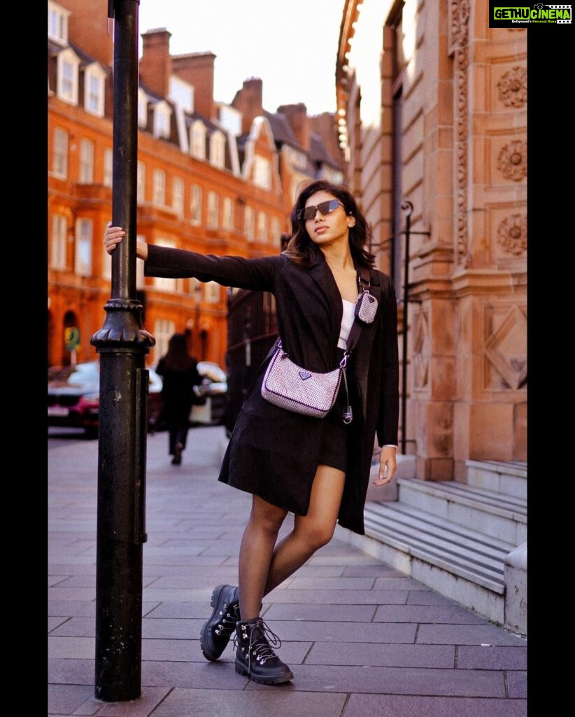 Dushara Vijayan Instagram - I’m a vibe that you can’t handle🖤 . . . Shot by : @georgesimon_m Bag : @prada Hairstylist : @renuka_mua #streetphotography #fashionblogger #fashionista #devilwearsprada #prada #black #style #styleblogger #styleinspo #fashionstyle #london #luxury