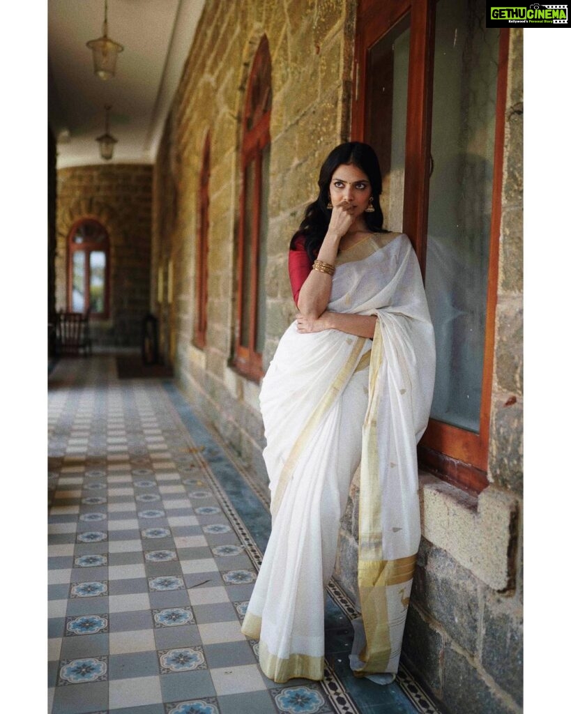 Malavika Mohanan Instagram - Happy Vishu everyone ✨♥️ It’s that one day in the year where I get to wear a traditional ‘kasavu’ saree without it feeling out of context, and maybe because I hardly get to do it is why I sway in the direction of always donning a classic one and nothing too sartorially adventurous. I wear it with jewelry strictly borrowed from mom’s closet because she has the most beautiful gold jhumkis & traditional temple jewelry, and ours seems to be the generation that has a general disdain for accumulation of gold jewelry(or is it just me?) Anyway, I digress. So coming back to Vishu and all things malayali, here are some pictures of me in a lovely palace estate in Kerala with the most beautiful corridors & the most stunning old trees which feeds right into my nostalgia trip of my malayali roots & strangely makes me feel at home even though it’s the first time I’ve visited this place. Ok. Time for some payasam now. So talk to you’ll soon and hope you had your fill of ‘sadhya’ today too ☺️♥️ P.S photos by the amazing @sbk_shuhaib & everything everywhere in life is pretty much courtesy @theitembomb