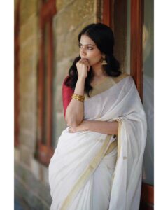 Malavika Mohanan Instagram - Happy Vishu everyone ✨♥️

It’s that one day in the year where I get to wear a traditional ‘kasavu’ saree without it feeling out of context, and maybe because I hardly get to do it is why I sway in the direction of always donning a classic one and nothing too sartorially adventurous. I wear it with jewelry strictly borrowed from mom’s closet because she has the most beautiful gold jhumkis & traditional temple jewelry, and ours seems to be the generation that has a general disdain for accumulation of gold jewelry(or is it just me?) Anyway, I digress. So coming back to Vishu and all things malayali, here are some pictures of me in a lovely palace estate in Kerala with the most beautiful corridors & the most stunning old trees which feeds right into my nostalgia trip of my malayali roots & strangely makes me feel at home even though it’s the first time I’ve visited this place. 
Ok. Time for some payasam now. So talk to you’ll soon and hope you had your fill of ‘sadhya’ today too ☺️♥️

P.S photos by the amazing @sbk_shuhaib & everything everywhere in life is pretty much courtesy @theitembomb