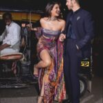 Priyanka Chopra Instagram - Date night and a 🛺….. with my forever guy @nickjonas Thank you @stylebyami as always for your amazing collaboration. I knew I wanted to wear an upcycled vintage look with a modern twist! So my outfit was an amalgamation of the east and the west! Like me! Thank you @amitaggarwalofficial for coming through and creating this handcrafted beauty with a story that is so apt for an evening celebrating Indian art and Fashion. This beautiful outfit was created using a 65 year old vintage Banarasi patola (Brocade)saree with silver threads and a gold electroplating on khadi silk. It is paired with a sequins sheet holographic bustier to reflect the nine colours of ikat weave that the brocade is set in. Thank you for your genius Amit and your gifted team. Congratulations #NitaAmbani and @_iiishmagish for creating an incredible exhibition of the history Indian fashion at the @nmacc.india! So proud of this exquisite space and the potential it has to promote Indian Art and design ❤️ Ps- Also for all wondering auto uncle took the cake! Was lovely and gracious! Thank you auto uncle! Mumbai, Maharashtra