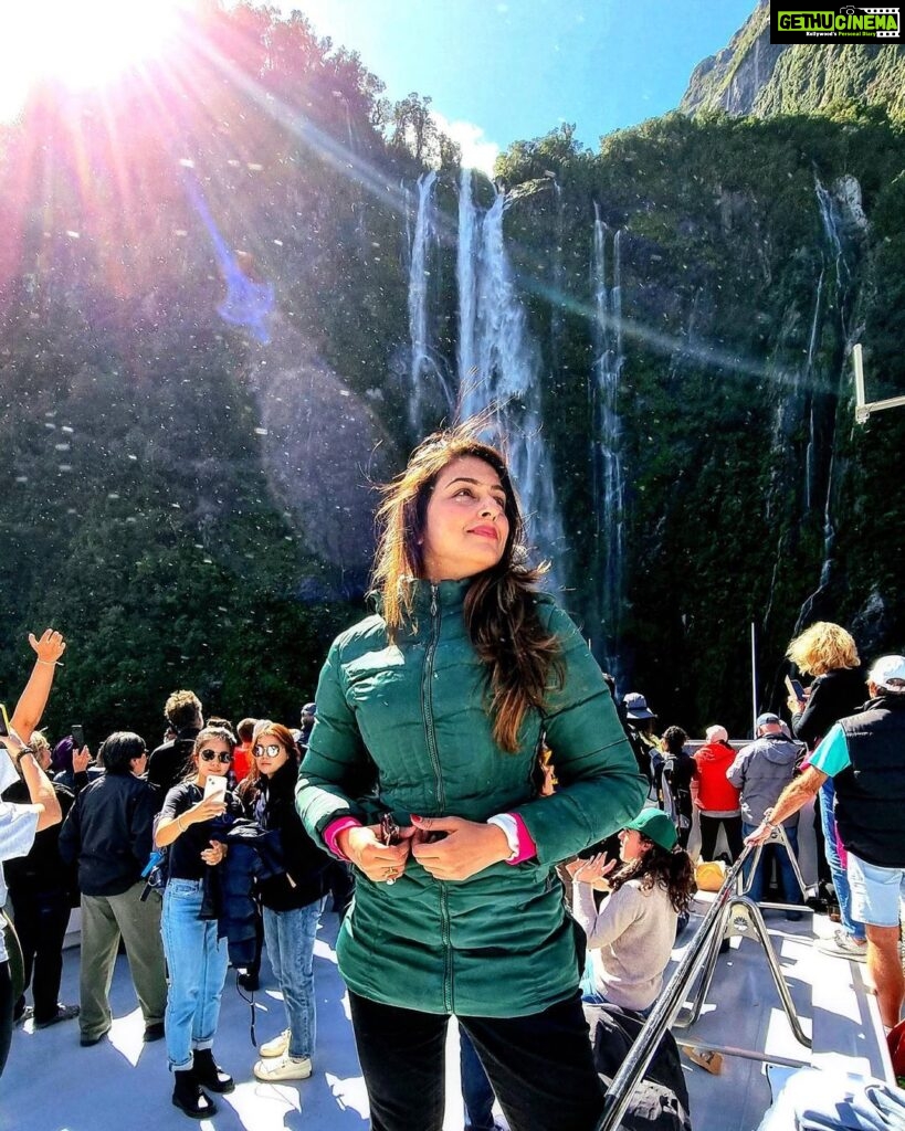 Aarti Chhabria Instagram - “Anything can make me stop and look and wonder, and sometimes learn.” —Kurt Vonnegut #quotes #goodmorning #milfordsound #aartichabria #greenjacket #waterfall #glare #sun Milford Sound, Fiordland National Park