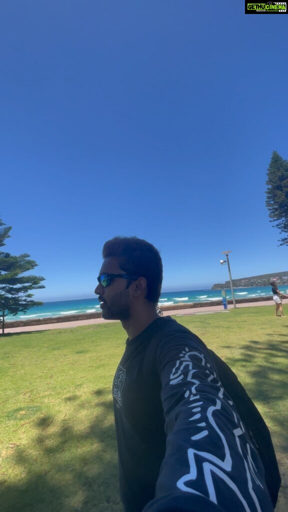 Abijeet Duddala Instagram - I'm doing something on the beach.. Taking the train day in and day out everyday like I did when I drove everyday to the mountains to learn to snowboard. What am I doing on the beach? Hint - I'm getting so tanned 😂 #beach #manly #PrimeReels #surf #straya Also this country has incredible sunsets! Manly Beach