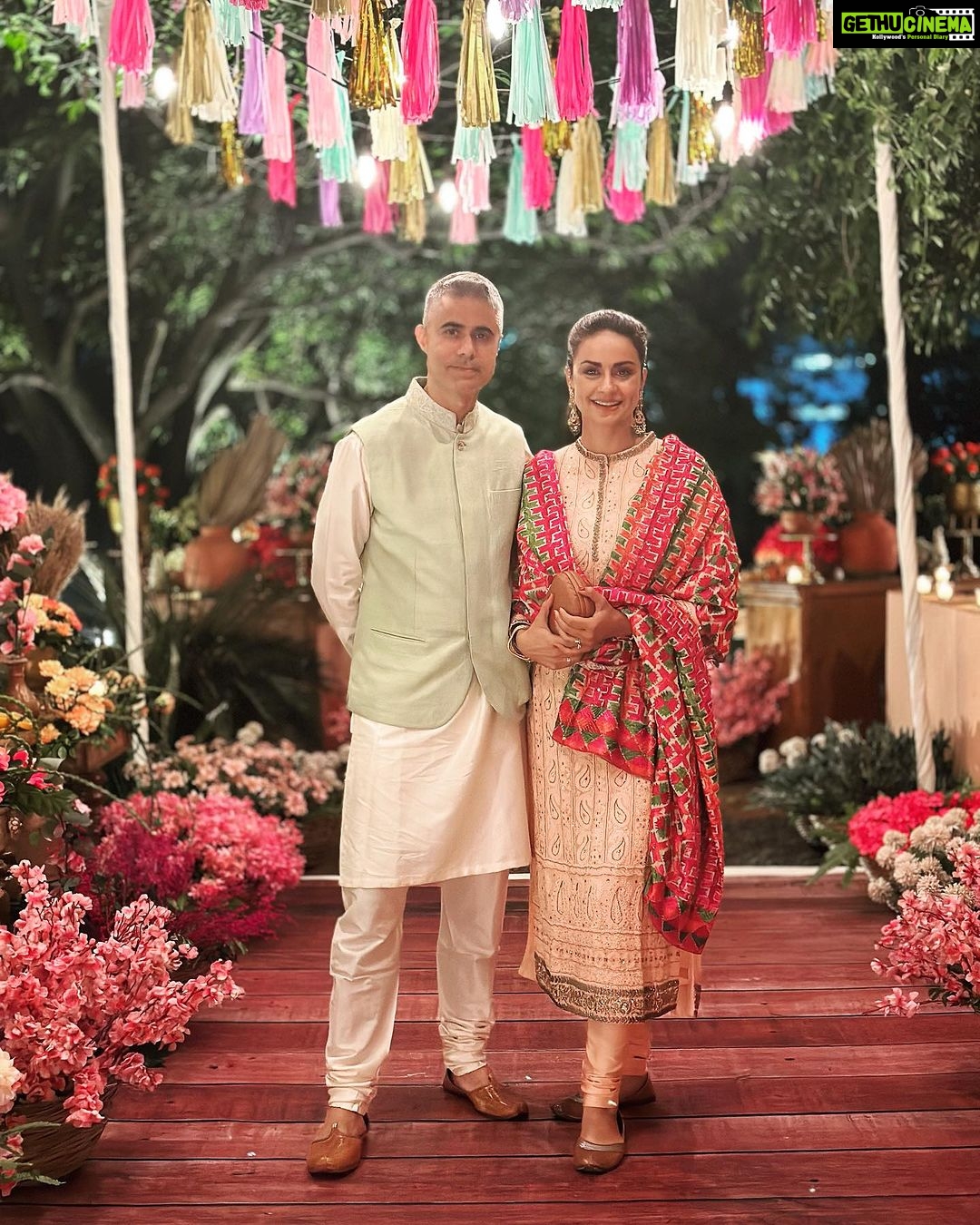 Gul Panag Instagram - The phulkari is such an integral part of our culture. From all things auspicious to all things festive -the phulkari is always there. Either as the main act. Or the supporting one, where we simply carry it on our forearms ( in addition to the full outfit and its own dupatta). At every wedding, shagan, engagement and jaago- the phulkari will ALWAYS make an appearance. Here I’m wearing a bagh ( all over embroidery) from @1469original . Occasion is Vatana. And my outfit is borrowed from @simranpotnis - we’ve decided to have all our clothes in JV now. 😅 Blue sari is @ritukumarhq . From 1999. Qualifies as vintage I suppose Also, managed to get HIM to pose for a picture.😅 @keeratkular thanks for the photos. And for reminding me that the knot clutch exists in my wardrobe. And of course for EVERYTHING else.😂 P.S Phulkari (ਫੁਲਕਾਰੀ) refers to the folk embroidery of the Punjab. Although Phulkari means floral work, the designs include not only flowers but also cover motifs and geometrical shapes. Incidentally, culturally prevalent in Punjab, Pakistan too.