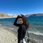 Palak Sindhwani Instagram - I get so lost in where I want to go, I forget that the place I’m in is already quite magical.🤍🦋✨ PS - It was -2 degree and was still trying to hold the pose! 😅 . . Top - @hm Pants - @urbanic_in Bag - @accessorizeindiaofficial Boots - @zara . . #postoftheday #travel #travelgram #leh #lehladakh #pangonglake #nature #traveler #fyp #explorer #palaksindhwani Pangong Lake