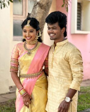 Deepika Venkatachalam Instagram - #Weddinglookbook 
Kerala themed Engagement (5/5) 💕✨

After that breathtaking lehenga, it was time to change for "Ring Exchange" 💍 and we had no heart to change the mood board and color palette for the second outfit! But wanted a quick changeover and went for this pleasantly beautiful gold saree that had a blush pink border adorned with motifs of the tree of life from @muhurth.brand ❤️ We looked into 50+ sarees from multiple brands but my heart said "Go for this"  RVP approved too! 🫶🏼

The saree by itself was a beauty and just to add some grace to it we went on to experiment with blouse designs. That's exactly when @d.sign.d came in and gave us a lot of ideas & finally our choice was this blouse with intricate embroidery that added a hint of simplicity, sophistication and tradition to the overall look❤️

Nextuhhhh....Jewelsuhh😌

Our pro stylist @artra_styling suggested to go for a bright temple look jewelery with bright red stones and emeralds to amp up the saree and I abided by it only to find the perfectly looking set from @vriksham that definitely added the touch of gorgeousness. ✨

Oh yes, for my groom! 🫶🏼 Raja wanted the changeover for the ring exchange to be simple. He preferred a "Veshti" and our stylish gave us the choice of pairing it with a Kurta in the same golden shade. 

As always, his silk veshti and his silk fabric for the kurta were picked from Nalli! 

We took it all to our Malar Akka @fiorebymalar_ and she made the kurta that looked so good on him! 🥺🫶🏼 
Like I said he wanted minimal dress up and just went ahead with his chain and bracelet only! 

I must admit it all fell in place so beautifully for both of us and we got lucky to figure out the finest people around us to ensure everything fell in place and our day was indeed filled with love and love only! 🫶🏼💕
.
📸 @photonimage_by_daran 
Decor @tharunam.in 
Jewellery @vriksham 
Saree @muhurth.brand 
Blouse @d.sign.d 
Styling @artra_styling 
Makeup @kabooki_mua 
.
#RnD #RnDwedding