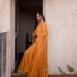Deepika Venkatachalam Instagram - #Weddinglookbook Mehendi ✨ !! (1/3) “An outfit that gleamed sunset🧡” The theme that we picked up for our mehandi was "Punjabi" & decided to go for outfits that resonated their culture and vibe. It was our stylist @stylingbysamiha who come forward to us and told us to choose from the native colours of Punjab like orange, green or purple to maintain the mood board and my mind immediately went to all those yesteryear Hindi movies where they graced around with patiaalas and short kurtas. @jigarmaliofficial had this gorgeous orange sharara set with an organza dupatta, gold dori & aari embroidery and it was love at first sight for me. I was already thinking of other occasions to wear this over and again! 🥹 Since the dress by itself spoke gorgeousness, samiha suggested minimal jewels that would resonate a Punjabi bride. She herself handpicked the dazzling Tikka and big jumkha from the brand @fineshinejewels and we loved how it complimented the outfit and it gave a neat finish as a whole. Neatly crafted outfit, droolworthy jewels, of course the stunning makeup from @vishualizemua , a cute max hairdo from @saisubha_hairstylist & my tiny shy from the bride to be face of mine gave the evening a whole different glow and I definitely felt right out of the book of an Indian Princess!!🥺 The evening set it's tone 🌥️with family and friends walking to our own terrace to have some fun talk, apply mehendi on their hands and some beautiful music to the ears! . . . . More to come!!! Wait for it!! . 📸 @sakshi.ramakrishnan #RnD #RnDwedding