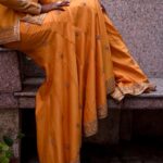 Deepika Venkatachalam Instagram - #Weddinglookbook Mehendi ✨ !! (1/3) “An outfit that gleamed sunset🧡” The theme that we picked up for our mehandi was "Punjabi" & decided to go for outfits that resonated their culture and vibe. It was our stylist @stylingbysamiha who come forward to us and told us to choose from the native colours of Punjab like orange, green or purple to maintain the mood board and my mind immediately went to all those yesteryear Hindi movies where they graced around with patiaalas and short kurtas. @jigarmaliofficial had this gorgeous orange sharara set with an organza dupatta, gold dori & aari embroidery and it was love at first sight for me. I was already thinking of other occasions to wear this over and again! 🥹 Since the dress by itself spoke gorgeousness, samiha suggested minimal jewels that would resonate a Punjabi bride. She herself handpicked the dazzling Tikka and big jumkha from the brand @fineshinejewels and we loved how it complimented the outfit and it gave a neat finish as a whole. Neatly crafted outfit, droolworthy jewels, of course the stunning makeup from @vishualizemua , a cute max hairdo from @saisubha_hairstylist & my tiny shy from the bride to be face of mine gave the evening a whole different glow and I definitely felt right out of the book of an Indian Princess!!🥺 The evening set it's tone 🌥️with family and friends walking to our own terrace to have some fun talk, apply mehendi on their hands and some beautiful music to the ears! . . . . More to come!!! Wait for it!! . 📸 @sakshi.ramakrishnan #RnD #RnDwedding