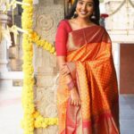 Deepika Venkatachalam Instagram - A combo of elegance and authenticity ft. @aaranyasilks ♥️ There's something always so special about kancheevaram sarees in our native colours la? Like Dhanush in yaardi nee mohini says, Red'uh nga! Red'uh thaan super ah irukum. It makes you feel like a family punch lamp (kudumba kuthu vellaku) 🙈🤣 One such saree is this maroon & orange combo one. While the pallu and border took the majority of maroon, the vibrant orange in the body part steals everyone's attention in the crowd. It's a pure handloom silk saree with pure gold zari, which gives you a royal look effortlessly. The body has the special velthaari zari checks(woven in hands) with thread motifs along with the traditional kanjivaram koravai borders. ( swipe left to have a closer look to the details) If you're someone who is looking for a simple yet classy kancheevaram saree, then this is a perfect fit for you. And guess what?! Their silk sarees price starts from just 6k and its a great steal for this wedding season. Deeii all you bride to be and brides maids, take notes olunga. Hehehe😌 Next...coming to the styling, we opted to style this saree with a plain blouse matching to the saree border, with a stack of contrast bangles, a gold jumkha and left the neck empty, to give the wide border the full credits to its beauty❤️ Special credits to @stitchhousesalem for stitching the blouse so fit and exactly the way I wanted. What do you think about it? And lemme know how you girls would style this saree in the comments below💭 . 📸 @kanmaniphotography Dolled up by @chisellemakeupandhair ( who happened to be my stylist as well 😂 ) and @saisubha_hairstylist . #deepika #chennaiblogger #chennaiinfluencer #styling #saree #bridalsarees