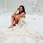 Megha Gupta Instagram - There is something strangely sacred about salt. Our sweat, tears, the sea, are all made up of salt. In the Bible, salt also came to symbolize purity, perfection, wisdom, hospitality, durability, and fidelity. I use salt for a physical and spiritual cleanse regularly. It repels evil spirits and absorbs any negative energy from a space. In this case, symbolises purification, protection, loyalty, and permanence. Salt is power. It might sound like alchemy, but the energy in places where salty ocean water and freshwater mingle could provide a massive source of renewable power. I recently discovered that I’m SALT (Single And Loving It), another version of “salt” these days 😂🤲🏻 I love when I find myself at the right place at the right time and presented myself with an opportunity where I visited Las Salinas in Cabo Rojo in Puerto Rico. Completely unplanned, turned the car around and had this adventure and I’m thankful for everything and everyone that played a part in this 🙏🏼 I’m engulfed in Indian Macarame and raw raw vast expanse of tones and tones of salt. It was hot, I couldn’t open my eyes with the Sun burning down on the gleaming white salt. The salt was burning but I felt this sacred energy in the air. Of the salt, the silence which was loud and reassuring, and immense peace. By doing just this, I consider my time in The USA a success. “Salt of the Earth” - Always. #salt #caborojo #puertorico #usa #centralamerica #carribbean #travel #salt #sacredsalt #macarame #red #white #summer #ootd #tan #traveller #meghagupta Cabo Rojo, Puerto Rico