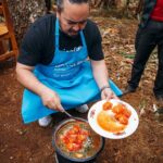 Adam Liaw Instagram – The most rewarding cooking demonstration I’ve ever done. 

Assisting UNICEF’s Mamans Lumière (Light Mothers) program in Ngozi Province. The Mamans Lumière program is where model mothers like Sibomana Christine teach young women about practical nutrition for their children.  Ngozi has one of the highest rates of childhood malnutrition in the world, with latest reports suggesting more than 60% of children experience stunting as a result of severe malnutrition. 

The Light Mothers teach about the balance and sources of macronutrients in ingredients that local women may be able to access, and UNICEF supplements this with a flavourless micronutrient powder containing essential vitamins and minerals for child development.

We made melangé, a nutritious Burundian stew made from whatever ingredients are on hand – in this case beans, lengalenga (amaranth, a Burundian staple), vegetables and small dried fish from Burundi’s Lake Tanganyika. 

The women said I was a good cook, but also commented that they had never seen a man cook before! Ngozi, Burundi