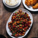 Adam Liaw Instagram – Tonight’s dinner. Gong bao ji ding (宫保鸡丁). A classic dish of Sichuan cuisine, but one that’s also been largely “lost in translation” creating so many misconceptions about Chinese cuisine outside China. 

It’s chicken flash fried with dried chillies, Sichuan peppercorns, spring onion and peanuts and within China it’s distinctive for (a) its seasoning profile of ma-la (hot and numbing) combined with sweet and sour, (b) being made with chicken breast, (c) and the inclusion of peanuts. 

It’s adaptations of “kungpao chicken”, “General Tso’s chicken” and “chicken with cashew nuts” largely remove the spice, replacing the dried chillies with capsicum and omitting Sichuan peppercorns, leaning more into a thick sweet and sour sauce, and use various nuts from almonds to cashews. 

It’s popularity, particularly in the US, has meant that  many people’s idea of a stir-fry is chicken breast, coated in a sweet and sour sauce with a lot of vegetables, and some nuts sprinkled in at the end “for crunch”, despite there being very few Chinese stir-fried dishes that do any of these things. 

So next time you see someone sprinkling sesame seeds over stir-fry, know that this dish is what started that kind of stuff.