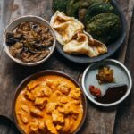 Adam Liaw Instagram - Tonight’s dinner. Butter chicken, hot and sour eggplant curry, paratha, spinach puri and chutneys. Butter chicken is the kids favourite, but I always try to make a hotter, more sour or bitter curry to offset the sweet, creamy and mild butter chicken. Paratha from the freezer, spinach puri and chutneys from @flyover_fritterie, everything else homemade.