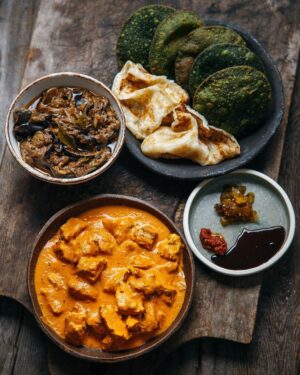 Adam Liaw Instagram - Tonight’s dinner. Butter chicken, hot and sour eggplant curry, paratha, spinach puri and chutneys. Butter chicken is the kids favourite, but I always try to make a hotter, more sour or bitter curry to offset the sweet, creamy and mild butter chicken. Paratha from the freezer, spinach puri and chutneys from @flyover_fritterie, everything else homemade.