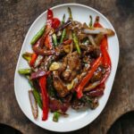 Adam Liaw Instagram – Tonight’s dinner. Beef, asparagus and capsicum with oyster sauce.

Stir-frying is all about technique, but that’s not to say that it’s difficult. I’ve changed the way I stir-fry over the years to make things more efficient for home cooking.

While restaurant cooking usually fries or oil-blanches the meat first, for home cooking I think it’s better to cook the vegetables first and then remove them from the wok to fry the meat second, returning the vegetables to the meat later. This avoids the need to wash the wok if any meat sticks to the metal (which it usually shouldn’t).

This recipe fries the asparagus, capsicum and onion first, then the beef second, tossing everything together with simple seasonings of oyster sauce, soy sauce, wine and sugar.

Recipe link in my profile.