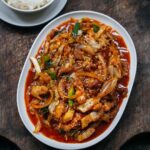 Adam Liaw Instagram – Tonight’s dinner. Butakimu. Japanese-style pork belly fried wok-fried with onions, gochujang and kimchi. The secret is a pat of butter tossed through at the end. 

One of the most important features I designed into the  Everyday range I made for @noritakeaus was the ability for it to adapt to the multiple cuisines that we eat in Australia. 

The oval share plate was specifically designed to be the perfect share plate for the centre of a rectangular dining table (think vegetables dishes, shared steaks, or really any shareable food), and of course it’s the perfect size for a wok-fried dish. The shape of the plate catches sauces to create a uniform white border which makes the food stand out. 

We most often combine that with the small bowl and plate, which I designed to function as a rice bowl and underplate with chopsticks, but the kids usually eat from the medium bowl if they’re using a fork and spoon.
