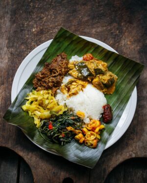 Adam Liaw Instagram - Yesterday I posted a picture of rendang, but I think it’s important to give those kinds of dishes context. I almost never make rendang on its own. It’s usually a celebratory food so there are plenty of other dishes that go around it like this plate of nasi kandar (or banana leaf). To make a meal like that takes a bit of balancing. 

Rendang the way I make it is rich, heavy, a little spicy (though not overly so) and kind of bittersweet in its taste profile. It would be overwhelming to have a meal of just that, so balance that I will always make something sweet and sour, in this case pickled Xinjiang chillies. 

There’s also a sour wild barramundi and okra curry. A mild dish of cabbage fried with turmeric and mustard seeds, a strongly savoury and fragrant kangkung belacan and there was also some fried chicken wings, and deep fried slices of bitter gourd and eggplant for both the texture and bitterness (not pictured).

Each of these dishes brings something to the overall meal that combines for something much greater than each individual part.  
It doesn’t get the same lens passed over it, but I think preparing a meal like this is as sophisticated an intricate as Japanese kaiseki or formal Chinese banqueting. 

In kaiseki the “rules” combine ingredients from the mountains, seas and forests cooked in different styles from steamed to fried to grilled. 

Chinese banqueting will follow mild dishes with stronger ones, steamed with fried etc. in the pursuit of balance. 

It’s all the same process of balancing that goes into preparing a good meal. I really think I should write a book about it because it’s something prevalent in almost all Asian cuisines, but not often discussed when those cuisines make it to the West.
