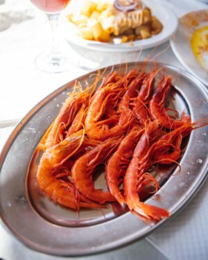 Adam Liaw Instagram - Spanish yum cha? Visiting my brother who lives in a village just outside Malaga. Seaside restaurants right on the beach serving seafood grilled over hot coals. Waiter walk around with the plates and you just grab what passes you by. The bill is tallied up at the end and written straight on the paper lining the table. With a few glasses of tinto de verano it’s the best way to spend a warm afternoon.
