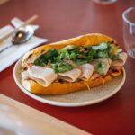 Adam Liaw Instagram - Our final episode of #AdamandPoh’s Great Australian Bites starts very soon on @sbsfood and we’re exploring @visitcanberra’s amazing food scene and FINALLY answering the question of what is Australia’s national dish? We eat what might be Australia’s best banh mi, make a pretty incredible bacon and egg roll, and put on the best sausage sizzle the country has ever seen, before having the results of our national dish poll read by a very special guest! …. … 🚨 It’s the Prime Minister. The special guest is the Prime Minister. 🚨 #visitcanberra