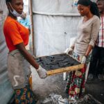 Adam Liaw Instagram - This is the UNICEF-supported #GreenGirls initiative where young women from #Sobel produce ecological charcoal from collected waste. We often think of the effects of climate change first impacting low-lying island nations, but #Sobel is a camp for more than 6000 Burundians who have been displaced because of extreme flooding caused by climate change. Climate change is already having a big impact on Burundi, from increasing frequency of extreme weather events like flooding, to decreased agricultural yields caused by prolonged rainy seasons. The Green Girls program an ingenious multi-dimensional solution to may of the problems facing these climate refugees. Firewood collection is a task usually performed by young women, who may have to walk for hours to find appropriate firewood. This exposes them to a high risk of sexual assault, and firewood collection contributes to deforestation. By producing ecological charcoal the girls don’t have to search for firewood, protecting them from potential assaults, and it also reduces deforestation and provides them with an additional source of income from the sale of surplus charcoal. An ingenious solution to a multi-dimensional problem. It was fabulous to see this initiative first-hand, chat with the girls and play with many of the kids from Sobel.