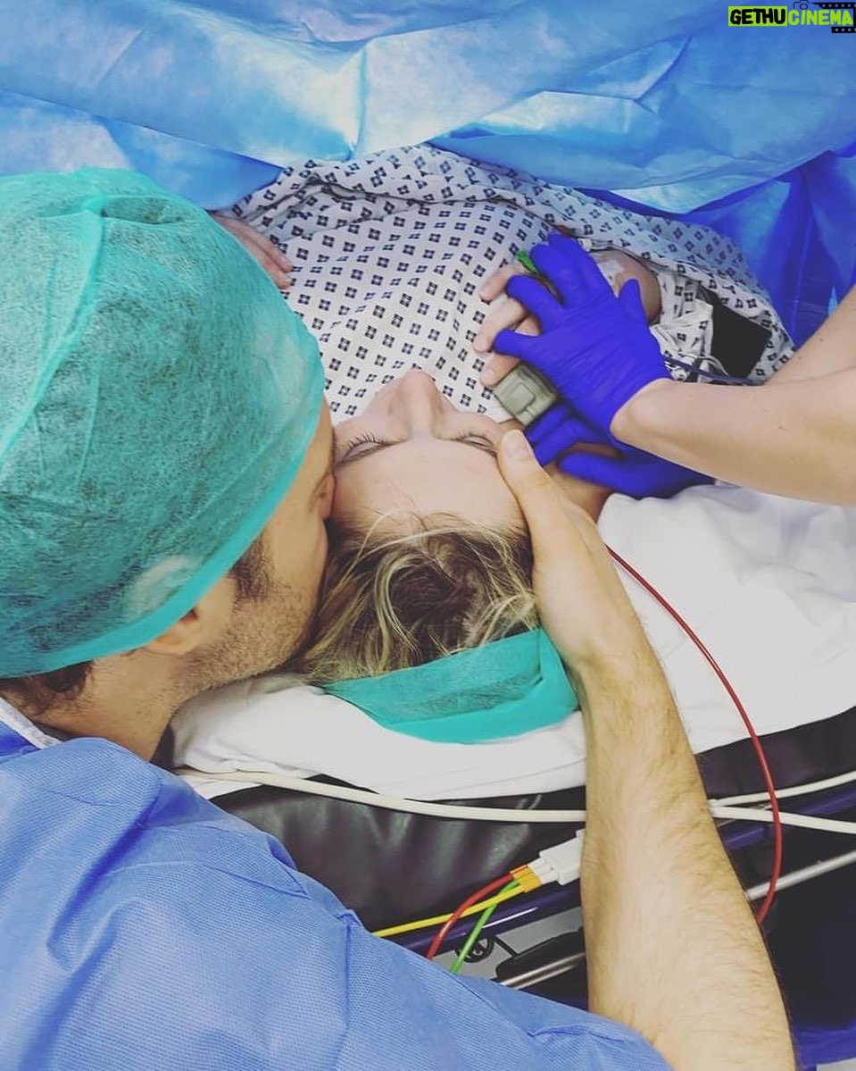 Ali Bastian - 766 Likes - It’s #csectionawarenessmonth I thought I would share my story again. The moment that changed my life forever ❤️
*We managed to get some incredible photos of Isla’s birth, courtesy of the operating theatre staff but this is one of my absolute favourites. This was moments before she was born. David is right by my side supporting me as always, but what I didn’t anticipate was that I would also have a right hand woman. Those blue gloved hands that are holding mine belong to her. Georgie, my anaesthetist. I was blown away by the kindness I experienced from all of the doctors, nurses and consultants... but this beautiful soul sticks firmly in my mind. As well as monitoring every aspect of my physical health and wellbeing, she somehow had the capacity to support me emotionally and mentally, talking me through every aspect of what was happening... Excitedly letting me know when it was nearly time to meet my baby and most memorably... holding my hand when I was scared. I was such a heady mix of excitement and anticipation... but also more nervous than I think I had ever been about anything. I had never experienced such a large medical procedure and when I arrived in the theatre, my teeth were chattering with adrenaline! My blood pressure dropped a couple of time during the op and she calmly and proficiently adjusted my sails and then held my hand to steady me. She made me laugh with her dry, razor sharp wit and showed me kindness and compassion when I cried and was overwhelmed with emotion. Thank you Georgie, I will never forget you. I’m so grateful to you and everyone at @chelwestft ... there are so many people that left such a lasting impression on me, I will definitely tell you about some of the others. I think about them all the time and pray they are keeping safe and well Xxxxx *