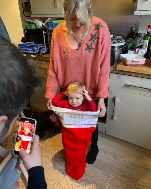 Ali Bastian Instagram - Christmas Photo Dump!!! 🎄🎄🎄 We felt so incredibly lucky to be able to share Christmas with my family given the absolute hellish lottery of the Covid situation at the moment. D had one day off Panto so Christmas Day was just the three of us…. With my fam popping in and out the rest of the time and a lovely late night doorstep visit from my in-laws. ❤️ 
📸 1.Christmas Eve game starting strong.
2. My mum upping the Xmas ante by putting my child in a stocking.
3. Bella (my Mum’s dog) and Isla were inseparable.  4. Christmas Morning… my little early riser discovering her new kitchen!  She makes a mean ‘cup of cino’ ☕️. 5. Getting a full Xmas dinner out of the oven by 12 so we could all eat together on Isla’s schedule meant we were all still in our pyjamas and no chance to run a brush through my hair or so much as stick on an eyeliner. It was chaos … but it was our chaos ❤️ 
6. … just because ❤️ .  7. Boxing Day … finally got some make up on and an ‘out fit’… David bought me a mini ring flash and I was trying to look cute… but just managed to look a bit dead eyed and weird 😂. 8. First time we ventured out of the house after living like hamsters for three days 🐹😂. 9. I LOVE this pic that my mum took and sent to me… I didn’t know it existed. It’s quite emotional to see myself looking so happy and relaxed. Isla has multiple allergies and weaning was a white knuckle ride. For a long time just setting foot in the kitchen I was on absolute red alert. This captures my baby enjoying her food and the simple joy that brings. It makes me realise how far we have come.
10. Merry Christmas ❤️🎄🌟