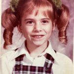 Amy Bailey Instagram - Fun fact: the night before my kindergarten photo I found some fingernail scissors and trimmed my own fringe (bangs 🇺🇸) into a really cool diagonal shape. ↘️ Only a 5 year old could rock up to a photoshoot with that whole hairdo, (vomit green pom-poms included) thinking, yeah I’m looking preettty cute rn.