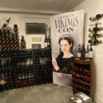 Amy Bailey Instagram - I was recently informed by a lovely fan that my enormous face from a poster signing at @germancomiccon now lives in their wine cellar. I promise you, @nido1443 , that smug expression is one of camaraderie. She won’t judge. She may have killed others with a glass of wine or two, but you’re safe…as long as you remain a loyal subject, that is. ⚔️👸🏻💀 #DontDrinkTheWine