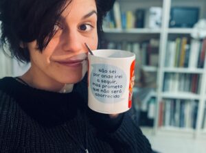 Anna Eremin Instagram - Tenho tanto na minha cabeça neste final de ano brutalmente violento que vou deixar aqui esta selfie com uma mensagem do Universo em forma de caneca ☕️ 
(Por acaso, o próximo passo eu sei, e é assustador - vou abandonar a magia da Mouraria e vou de malas e bagagens para uma casa grande, com um terreno grande. Vou passar a passear cães de manhã e vou ter um burro no quintal. Eu, a miúda da cidade… vou passar a ter uma lareira para acender à noite e acordar com o canto dos passarinhos de manhã. Dito assim, nem parece tão assustador. Contudo, acho que a primeira coisa a fazer é arranjar umas galochas cor-de-rosa 😂)