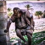 Arash Mir Ahmadi Instagram - چند سال پیش جوانان محل تصمیم گرفتند عمو حاجی را بعد از شصت سال دوری از آب به رودخانه ببرند تا آبی به بدن این مرد برسد، به همین منظور هنگامی که عموحاجی خواب بود او را عقب یک وانت گذاشتند تا در رودخانه حمامش کنند اما وقتی به رودخانه رسیدند، دیدند عمو حاجی در عقب وانت نیست زیرا او پیش از رسیدن، خود را به بیرون از وانت انداخته بود تا مبادا بدنش با آب آشتی کند و عمو حاجی همان جا گفته بود که اگر تمیز شوم، مریض می‌شوم. حالا دیگر زمین‌گیر شده سن تقریبی او ۸۰ سال است، در کوه‌ها و جنگل‌های اطراف دهستان دژگاه فراشبند زندگی می‌کند و عاملی که موجب تعجب همه شده این است که او هیچگاه از آب و غذای بهداشتی استفاده نکرده و اتفاقاً این عامل باعث نشده تا به بیماری‌های مختلفی دچار شود چون گروهی از پزشکان که آزمایش‌های مختلفی را روی او انجام داده‌اند، متوجه شدند که سالم است این سالخورده که گفته می‌شود به دلیل مشکل عاطفی که در ایام جوانی برای او رخ داده از مردم و اجتماع گریزان و گوشه عزلت و انزوا برگزیده، سالیان سال است که زیر مکانی مسقف مأوا ندارد و در گرما و سرما در هوای آزاد به سر می‌برد. برخی از جوانان و نوجوانان دژگاه برای عمو حاجی مرغ، گربه، روباه، خارپشت و حتی مار مرده می‌برند. او این حیوانات را در گودالی در اطراف خود دفن می‌کند و پس از چند روز که گندید و نرم شد با ولع خاصی می‌خورد. عمو حاجی پس از آن با خوردن آب گندیده که در یک حلب زنگ زده و حشرات مختلف در داخل آن شناور هستند، وعده غذایی را به پایان می‌برد. لیوان او یک حلب ۵ /۴ کیلویی روغن است و او با استفاده از این حلب روزانه نزدیک به پنج لیتر آب می‌نوشد. لباس پوشیدن این مرد در دهستان دژگاه که دارای گرمای نزدیک به ۵۰ درجه سانتیگراد است، شگفتی‌آور است زیرا او تمام لباس‌هایی را که مردم این منطقه برایش می‌آورند، پس از بریدن آستین‌های پیراهن و پاچه‌های شلوار با دندان، بر تن می‌کند. لوازم زندگی او شامل یک چماق است که پیشتر پلوس وانت بوده و وزن آن ۱۷ کیلوگرم است. استکان چایخوری این مرد عجیب یک کلاه ایمنی اسقاطی و چند حلب کهنه روغن نباتی است که بچه‌های این دهستان با آفتابه در این حلب‌ها برای او آب می‌ریزند. متاسفانه چنان وضعیتی از این مرد نشان داده‌اند که انگار با یک مرد وحشی رو به رو هستیم در حالی‌ که اگر کسی با او هم صحبت شود هیچوقت از مهربانی او خسته نمی‌شود.