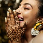 Arjun Kamath Instagram – It was the day of her mehendi, and @lakshmiambarish  had been patiently getting her hands painted while her loved ones were immersed in merriment. In the moment of freedom following the hours of being anchored, she let out a peal of laughter at some inside joke. At the time, the sun was setting outside her home and it appeared that her smile had taken over the responsibility of lighting up the room. That’s when I photographed this candid moment, capturing the ebullient charm of the free-spirited bride. Shortly after, I found myself thinking how beautiful it is to be lost in a moment of love and happiness when everyone you cherish is right by your side.

#CapturedOnCanon with a Canon EOD 5D Mark IV 

Lit with a @profotoglobal B10
@srishtidigilife @canonindia_official 

Makeup @vikrammittal5 
Hair @awon.wungkhai 

#arjunkamathphotography #bride #happy #portait #laughter #wedding #weddingphotography #photography #eosmaestro #mentorsinfocus #weddingsutra #wedmegood #photobugcommunity #photobug #bridesofindia #junebug #mywed