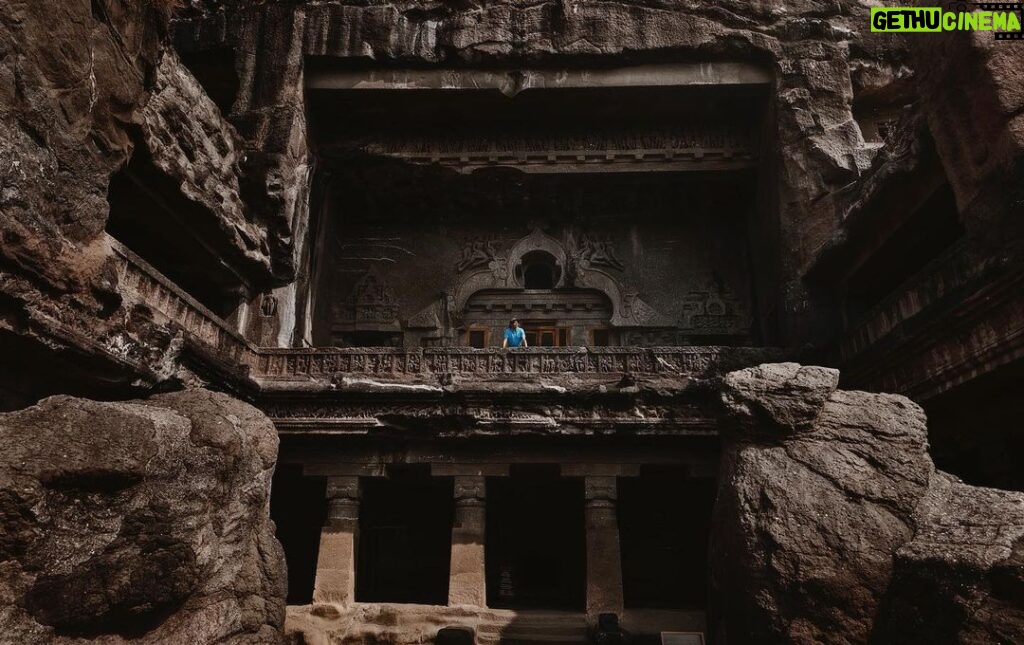 Arjun Kamath Instagram - I was recently in Aurangabad with mum and dad, where we made the unmissable trip to the marvellous caves of Ellora. A cluster of 34 caves dedicated to several religions and showcasing different architectural styles, the place was an enigma that unfurled slowly. This particular picture is of Cave 10, a majestic Buddhist monastery cum cathedral that left me awestruck in a single gaze. It was a sunny afternoon and I was walking around in admiration of the archaic beauty all around me, when I came across this stunning facade. Instantly, I froze at the splendour of it all, and it didn’t take me two seconds to find the perfect frame that I wanted to shoot. Knowing that my parents had already ventured inside the cave, I decided to sit down on the damp ground without any care in the world. I was curiously waiting for them to wander into the balcony at some point, all set to freeze the moment. As soon as my father stepped in, I waited for the tourists to move away and requested him to walk to the edge of the balcony. Watching him stand there wearing a contrasting blue against the rustic brown cave, I felt like a child who had been surprised with candy and thus couldn’t hold his excitement. Dad lingered there for a while and then carried on since it was sweltering hot. But it was time enough for me to get the shot, almost as if my muscle memory had taken over, scouting the perfect composition and then clicking the shutter button on my camera. And although I rarely share wide shots of my travel stories, my eyes are accustomed to see the world in terms of stories and enticing frames. So, whenever I see one, I can’t help but take a photograph. This time around, the moment was all the more special, since I had the pleasure of having someone from my family grace the frame, adding a personal connection to it. #CapturedOnCanon with a Canon EOS 5D Mark IV & a Canon EF 24-70mm F/2.8 II USM Standard Zoom Lens #arjunkamathphotography #dad #elloracaves #india #DoGreatWithCanon #MentorsInFocus #EOSMaestro Ellora Caves, Aurangabad