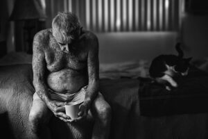 Arjun Kamath Instagram - Super glad that my entry ‘Holding On...’ was awarded an Honourable Mention (Portrait, Professional) at the Monochrome Awards 2020.

The story behind the image: 
I made this image of Robert Weiner, a Los Angeles based actor, in his studio apartment in Chula Vista, LA. Often the images that appeal to me the most as a storyteller originate from the simpler, everyday moments of life. Robert sits on the bed, lost in his thoughts, accompanied by his cup of coffee and pet cat on an overcast LA morning. Shot in the city where golden dreams brew, the picture brushes the thought that LA is vibrant, but at the same time, it can also make one feel left out in an instant with its fast-paced life. Resonating with this idea, I envisioned the photograph in black and white, as the frame confirms a personal belief. That in the end, we are all alone in fighting our own battles, one day at a time. This photograph is hence all barebones, visually conveying the philosophy of life through powerful emotions and a simple story, both enhanced by the deprivation of colours. In the viewer, it also enlivens the familiar reality of old age and the challenges it brings. And while old does not mean different, things slow down for sure. Thus, in the picture, the cat leaving the frame contrasts with the evident stillness of the old gentleman. It also metaphorically conveys that he will soon be alone, adding another flavourful layer to the image.
 

#CapturedOnCanon with a Canon EOS 5D Mark III

#arjunkamathphotography #award #honourablemention #blackandwhite #monochromeawards #instagram #DoGreatWithCanon #MentorsInFocus #EOSMaestro